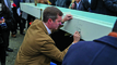 Kentucky Gov. Andy Beshear signs a beam that was installed at the battery plant Ford is building in Glendale, Ky.